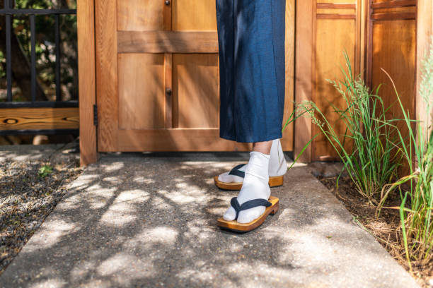 Feet of man in kimono costume and geta tabi shoes socks in outdoor garden in Japan by wooden modern contemporary door Feet of man in kimono costume and geta tabi shoes socks in outdoor garden in Japan by wooden modern contemporary door geta sandal photos stock pictures, royalty-free photos & images