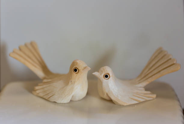 istock wooden bird figurines on white ground 1161806761