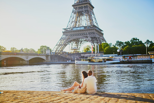 Happy romantic couple in Paris, near the Eiffel tower. Tourists spending their vacation in France