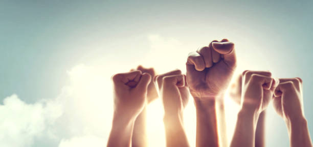 Peoples raised fist air fighting and sunlight effect, Competition, teamwork concept. Peoples raised fist air fighting and sunlight effect, Competition, teamwork concept. independence concept stock pictures, royalty-free photos & images