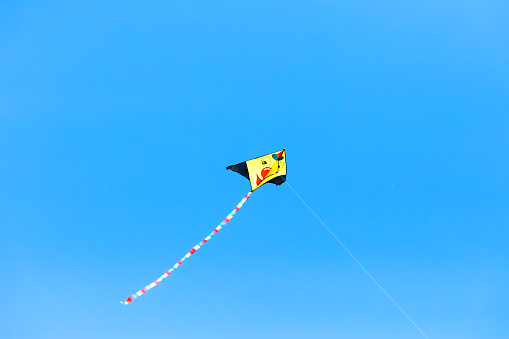 Funny kite flying in a blue sky. Space for copy.
