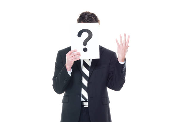 istock Handsome businessman wearing a black suit - is hiding behind a question mark sign 1161817436