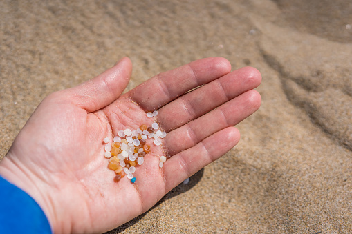 Woman holding small tiny harmful plastic microbeads collected on the beach in Zante, Zakynthos, Greece