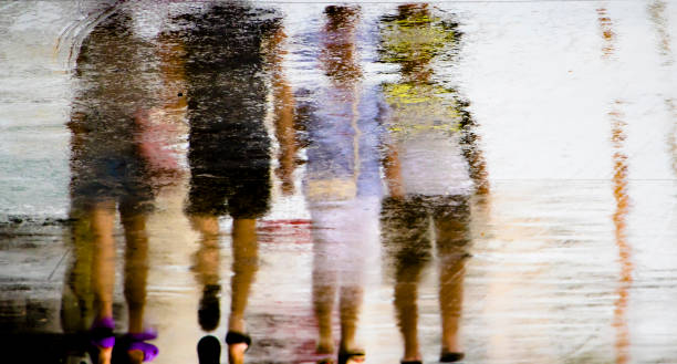 istock Blurry reflection silhouette  in a puddle of people walking on a rainy day 1161820273