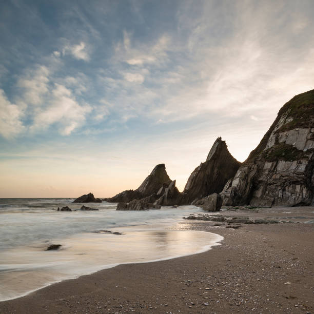 istock Stunning sunset landscape image of Westcombe Beach in Devon England with jagged rocks on beach and stunning cloud formations 1161822539
