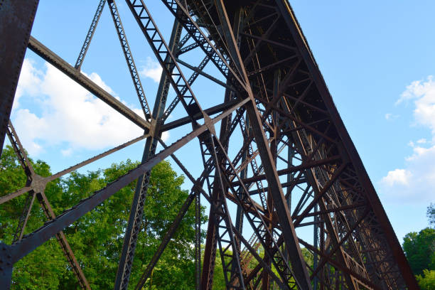istock Rusty, brown metal rail road bridge from below. Railway steel bridge structure. 1161824323