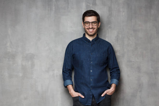 istock European guy holding hands in pockets looking at camera with friendly smile, isolated on gray background 1161827765