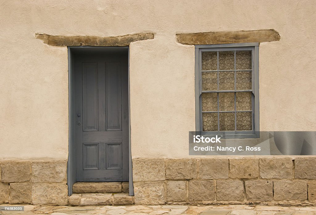 Door and Window in Adobe Wall, Southwest Style Architecture, Rough-Hewn Old adobe wall with faded door and window in historic district, Tucson. Adobe - Material Stock Photo