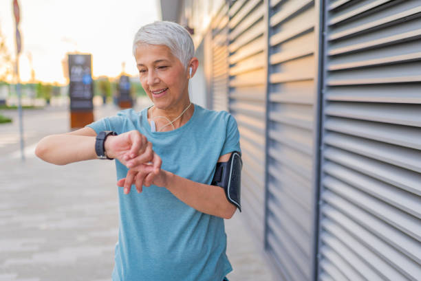 Checking the pulse. Mature Runner Checking Smart Watch. Checking Fitness Statistics On Smart Watch. Athletic mature woman monitoring her running performance on smartwatch wearable computer stock pictures, royalty-free photos & images