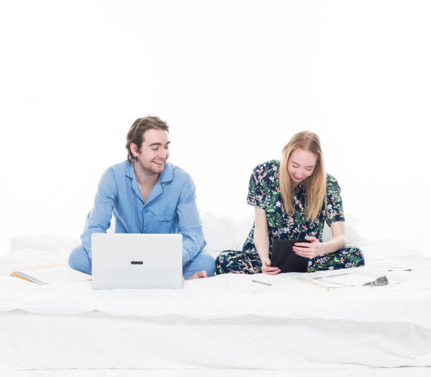 istock Two people sitting up in bed working 1161837542