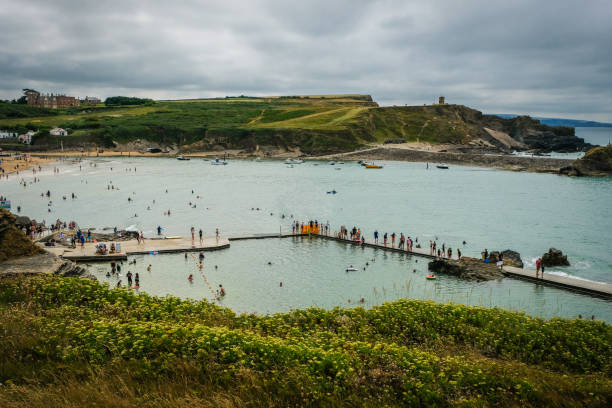 люди, имеющие летний пляжный отдых в bude sea pool на пляже саммерлиз, северный корнуолл, англия - tide rock bay landscape стоковые фото и изображения