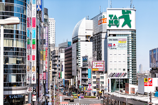 Taito City, Japan - May 28, 2023: View west from Azuma Bridge to the red and green Asakusa Station entrance to the Tokyo Metro. Kaminarimon Street is to the right, lined with retailers and the Kaminari Gate in Asakusa district.