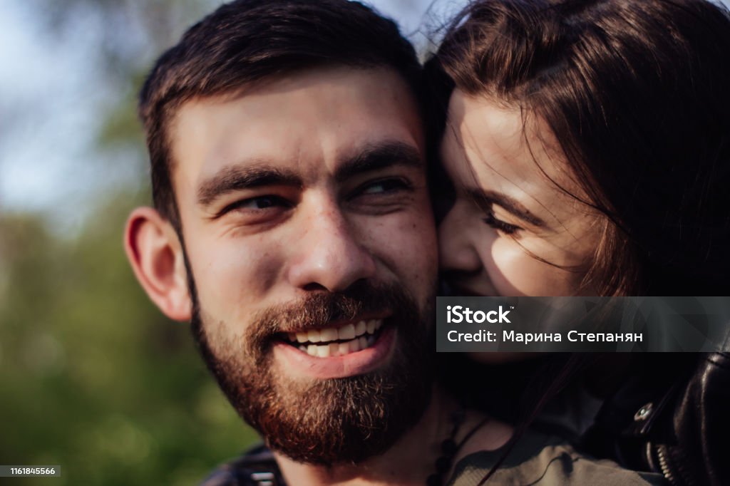 Head shot of young affectionate romantic couple in love. Close up portrait of attractive brunette girl and guy with eyes closed, close to each other. Concept of first kiss, tenderness and amorousness Adult Stock Photo