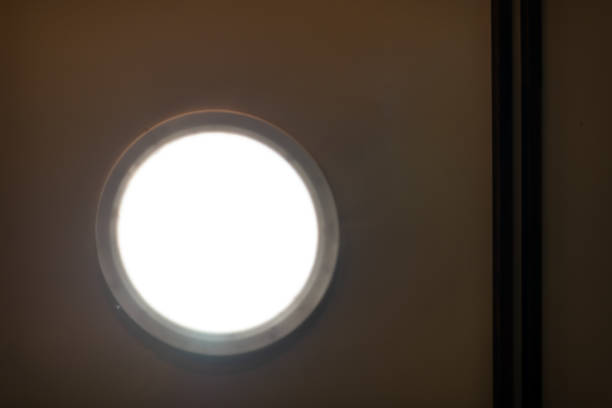 Abstract closeup of modern small skylight in room bathroom with white light on ceiling