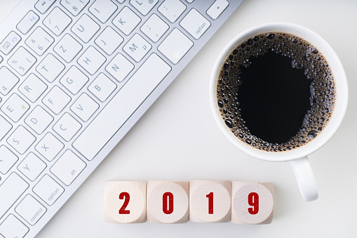 cubes in front of a keyboard and coffee showing 2019 on top