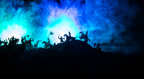 istock Medieval battle scene with cavalry and infantry. Silhouettes of figures as separate objects, fight between warriors on dark toned foggy background with medieval castle. 1161848508