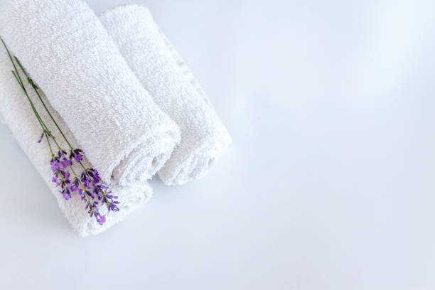 white clean towels and lavender flowers on white isolated background