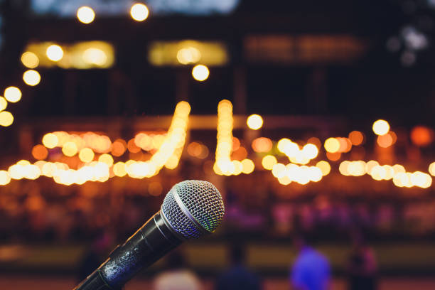 microphone on a stand up comedy stage with colorful bokeh , high contrast image. stock photo