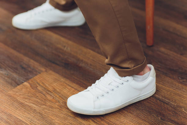 istock White sneakers,lower half, legs, on wooden boards. 1161854864