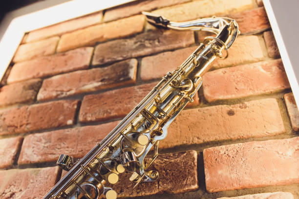 istock Saxophone leaning against a yellow brick wall. 1161854885