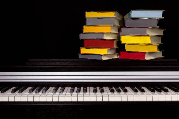 istock stack of colored books on the piano on a black background. 1161857846