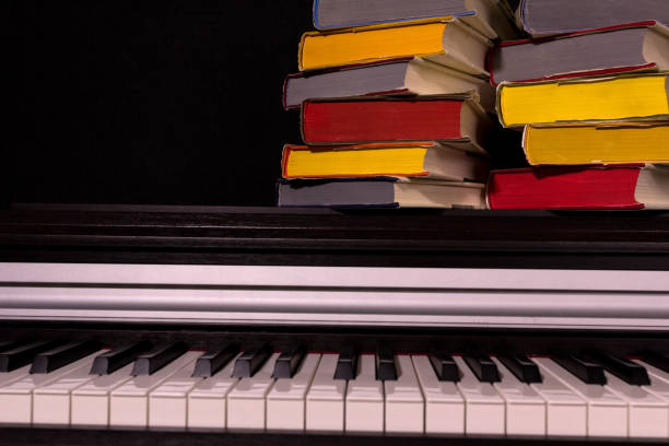 istock stack of colored books on the piano on a black background. 1161857862