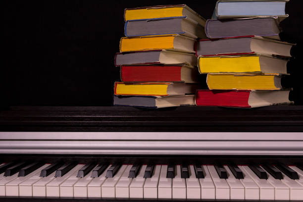 istock stack of colored books on the piano on a black background. 1161857863