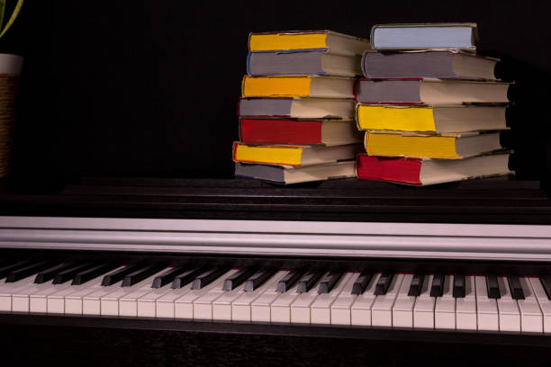 istock stack of colored books on the piano on a black background. 1161857871