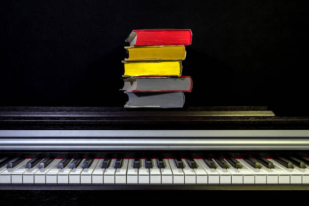 stack of colored books on the piano on a black background. Concept of education and reading.