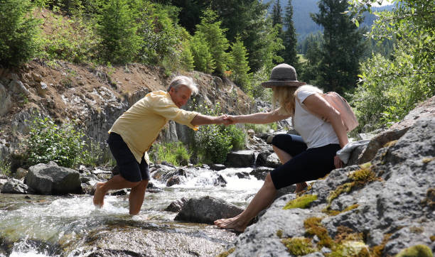 istock Mature couple cross mountain stream in forest 1161861314