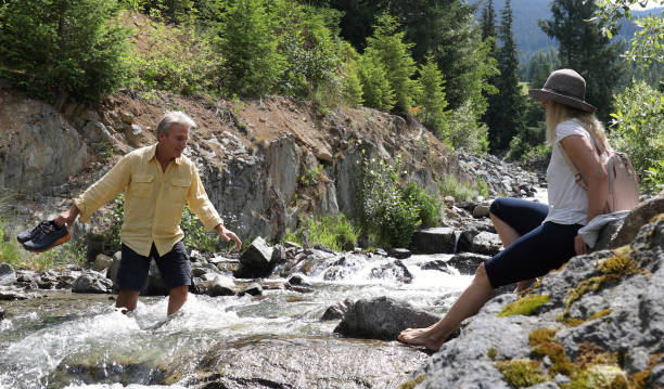 istock Mature couple cross mountain stream in forest 1161861355