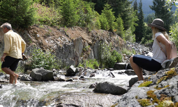 istock Mature couple cross mountain stream in forest 1161861363