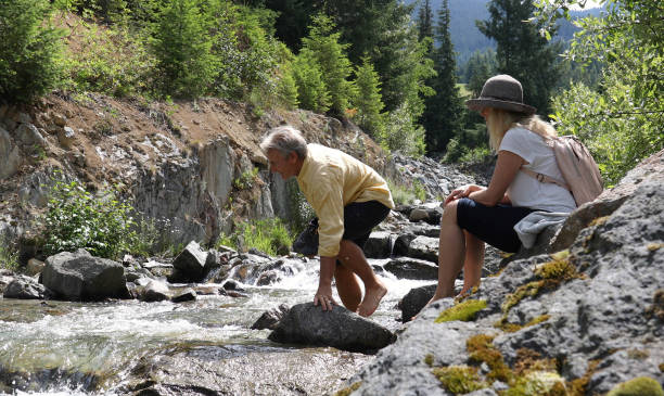 istock Mature couple cross mountain stream in forest 1161861386
