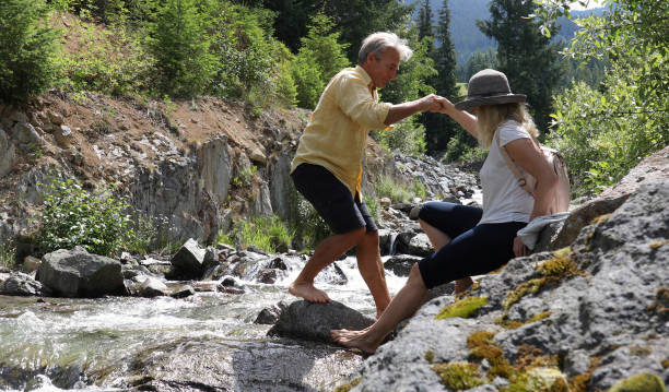 istock Mature couple cross mountain stream in forest 1161861439