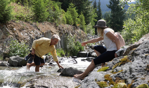 istock Mature couple cross mountain stream in forest 1161861458