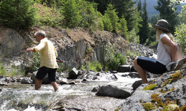 istock Mature couple cross mountain stream in forest 1161861466
