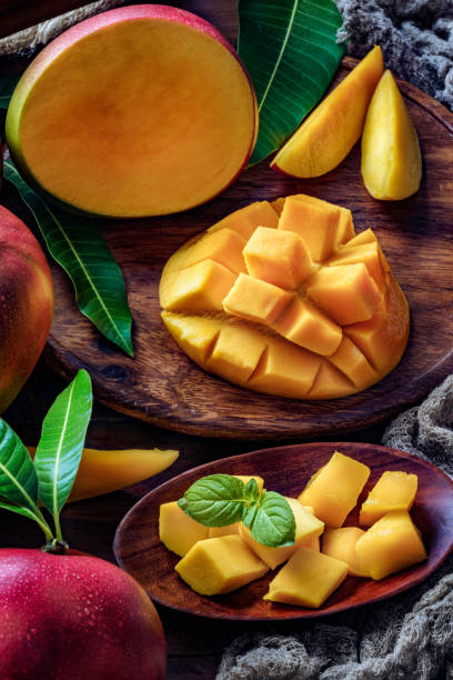 istock Tropical Fruits: Sliced mangos in a wooden plate on a table in rustic kitchen 1161865657