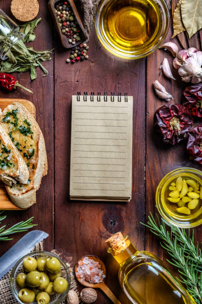 snack o aperitivo de albahaca de ajo y bruschetta de aceite de oliva sobre la mesa con un cuaderno y espacio de copia. - bruschetta cutting board italy olive oil fotografías e imágenes de stock