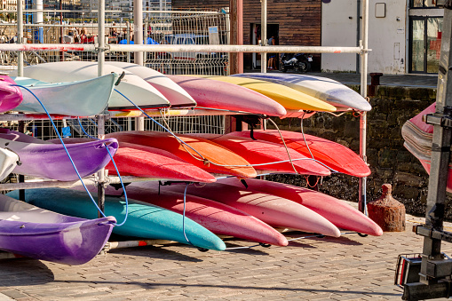 Stack of kayak and sailboats at a public harbor, Asturias, Spain