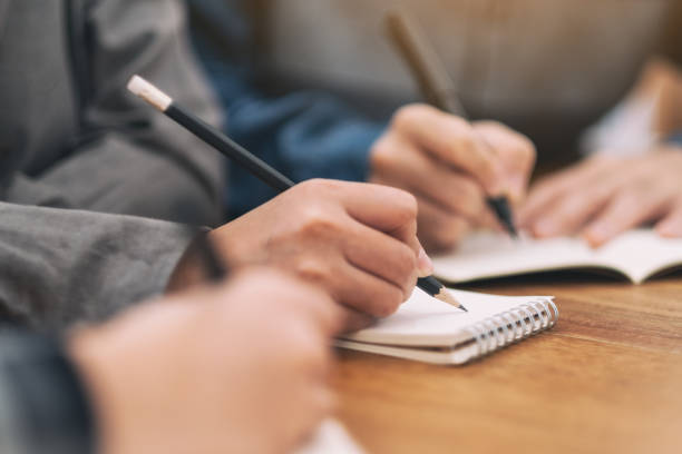 istock people writing on blank notebook together on wooden table 1161881692