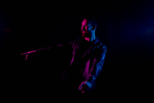 istock Attractive man with black shirt and leather jacket and gel lighting 1161890922
