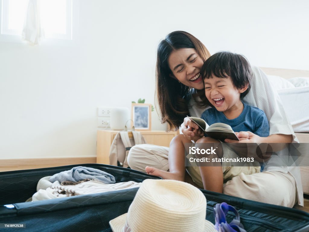 Family preparing for the journey Young asian woman and little baby boy preparing for road trip at home. Family Stock Photo
