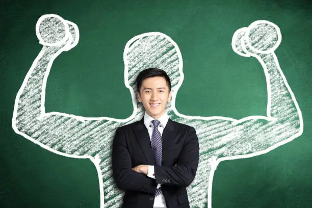 Photo of smiling asian business man with power gesture