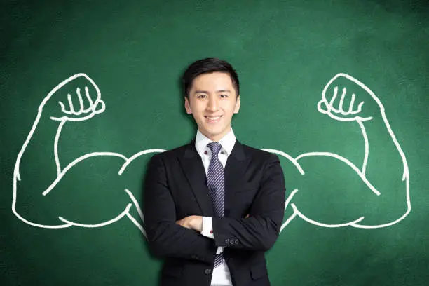 Photo of smiling asian business man with power gesture