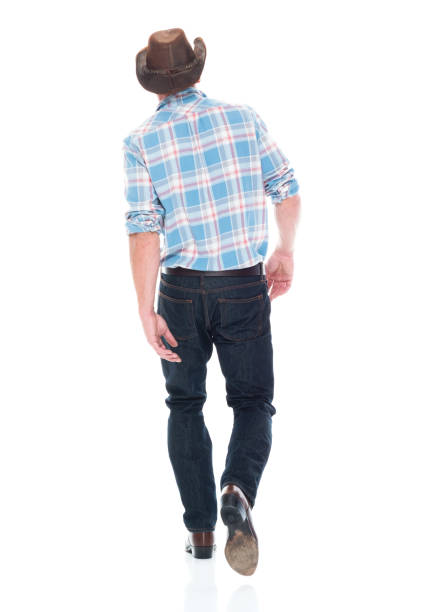 istock Handsome cowboy is walking, rear view 1161893484