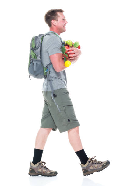l'escursionista maschio amichevole tiene una varietà di frutti e cammina - men banana holding cut out foto e immagini stock