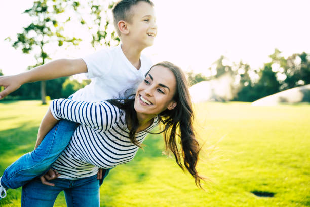 istock Happy beautiful young mother is playing with her little son while he is riding on her back and shouting for joy. 1161894431
