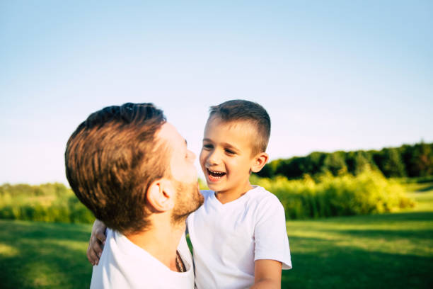 istock Handsome young modern father has a fun and vacation day with his little beautiful son outdoors in city park 1161894596