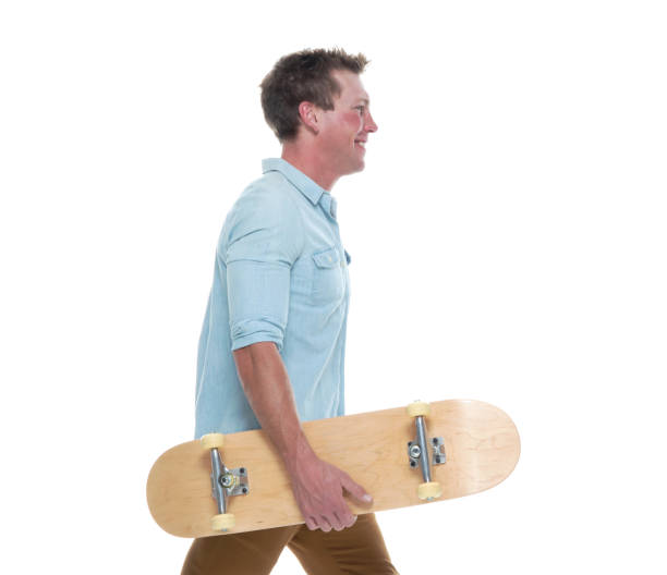 istock Casual well dressed man walking with a skateboard 1161895551