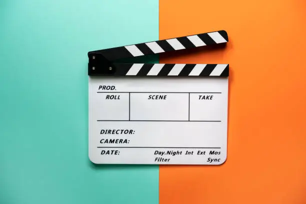 Photo of movie clapper on color table background; film, cinema and video photography concept